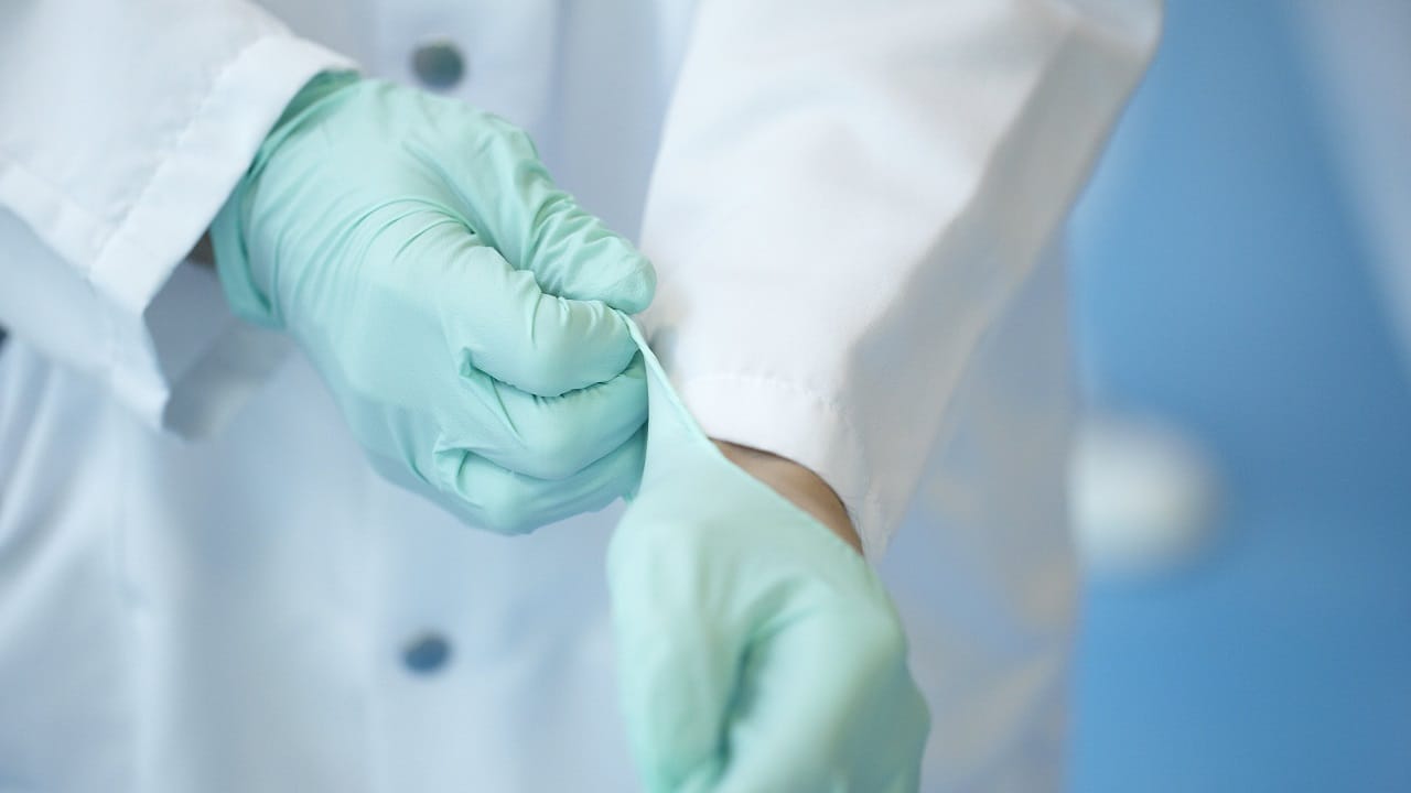 Profissional de saúde coloca luvas