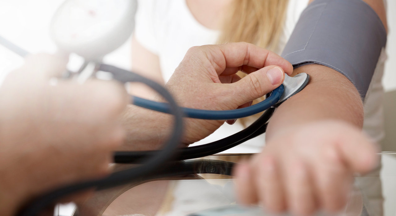 Médico mede pressão arterial a uma paciente