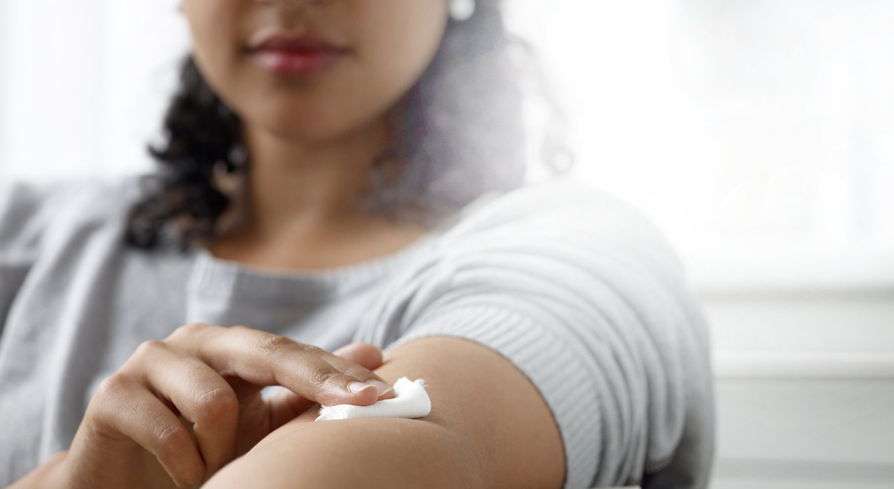 Mulher pressiona braço após colheita de sangue para análise